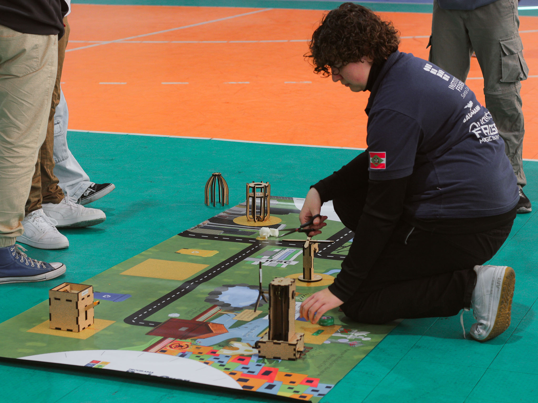Adolescentes e jovens participam do Torneio de Robótica Pode Crer no IFSC Florianópolis, programando e testando robôs em uma arena temática sobre sustentabilidade.