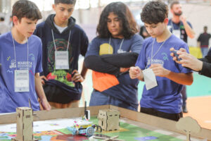 Adolescentes e jovens participam do Torneio de Robótica Pode Crer no IFSC Florianópolis, programando e testando robôs em uma arena temática sobre sustentabilidade.