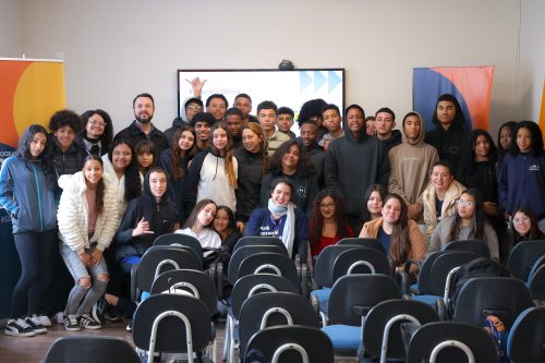 Grupo de jovens e educadores do Programa Pode Crer reunidos em sala de atividades, posando para foto coletiva.